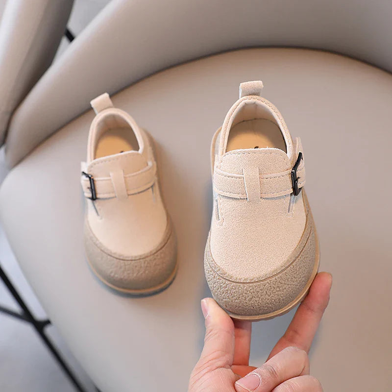 Beige baby shoes showing rounded toes, buckle details, and heel pull tabs