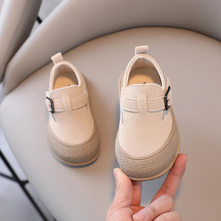 Beige baby shoes showing rounded toes, buckle details, and heel pull tabs