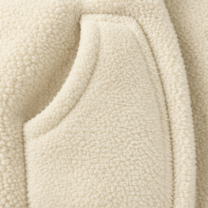 Curved side pocket on the textured beige babywearing jacket