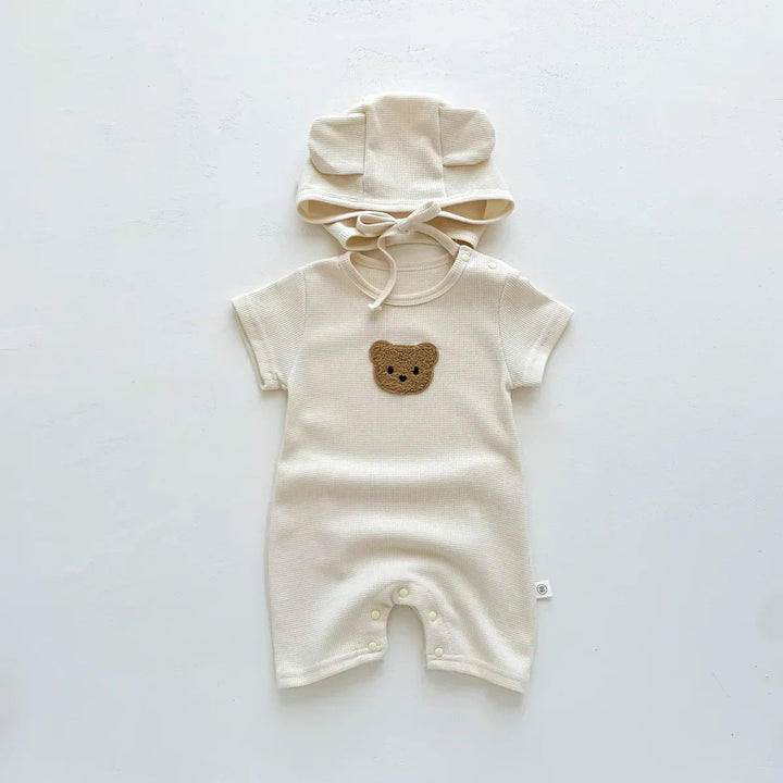Beige bear-detail baby romper with leg snaps and a matching tie hat