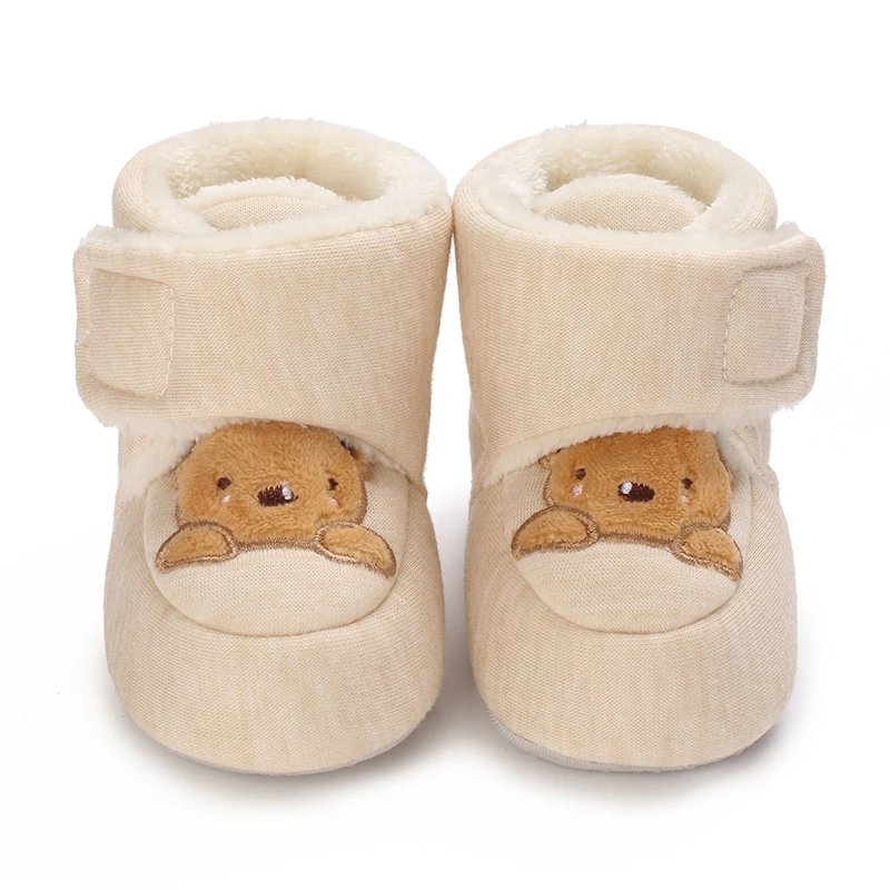 Front view of beige baby shoes with brown bear faces and wide ankle straps