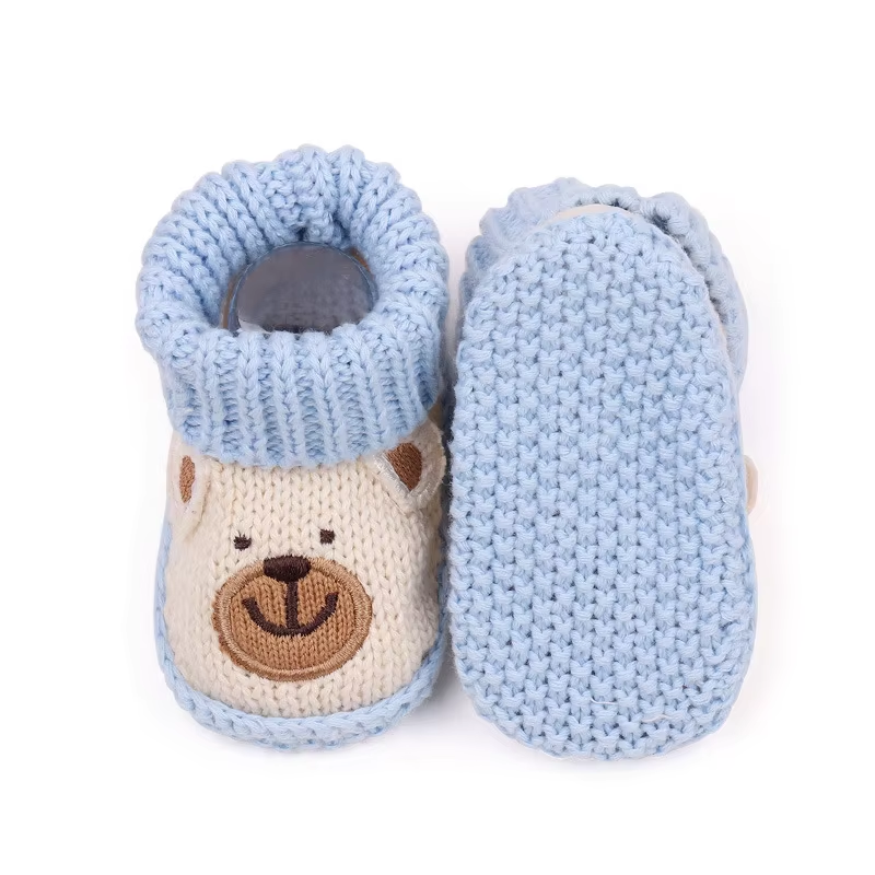 Beige bear baby booties showing the front design and full light blue sole