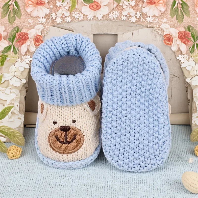 Beige bear knitted booties showing the opening and textured light blue sole