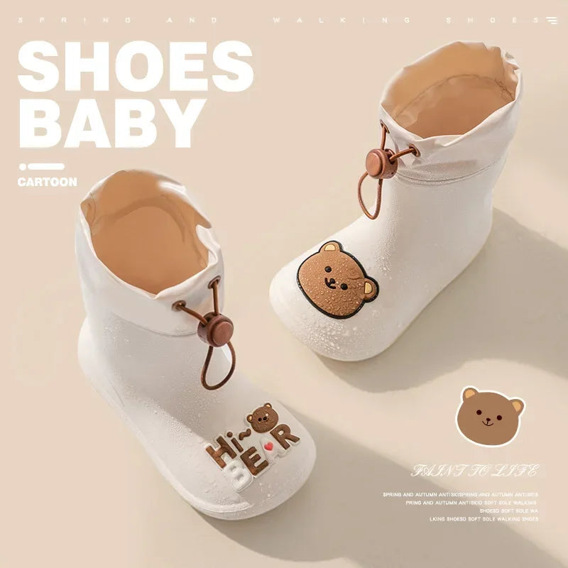 Overhead view of beige bear rain boots with drawstring cuffs