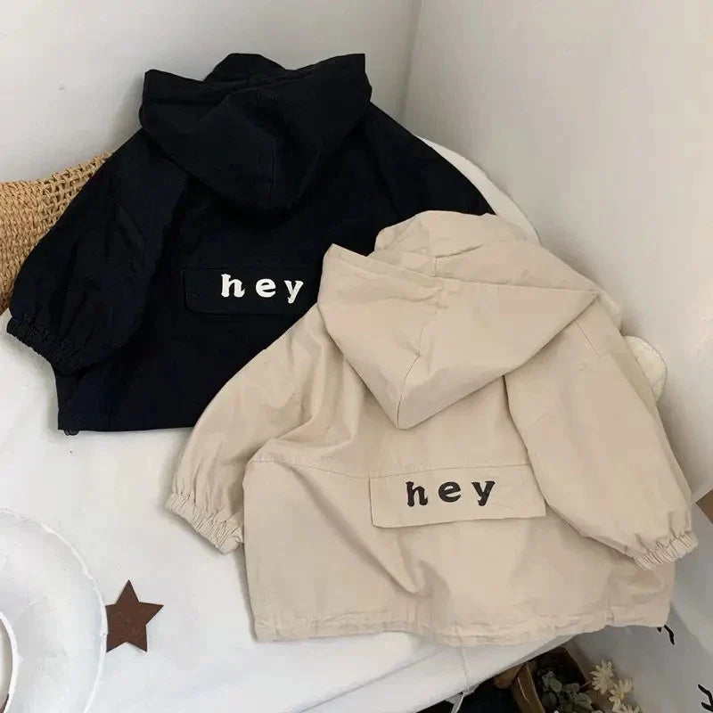 Back view of beige and black hooded jackets with lettered panels