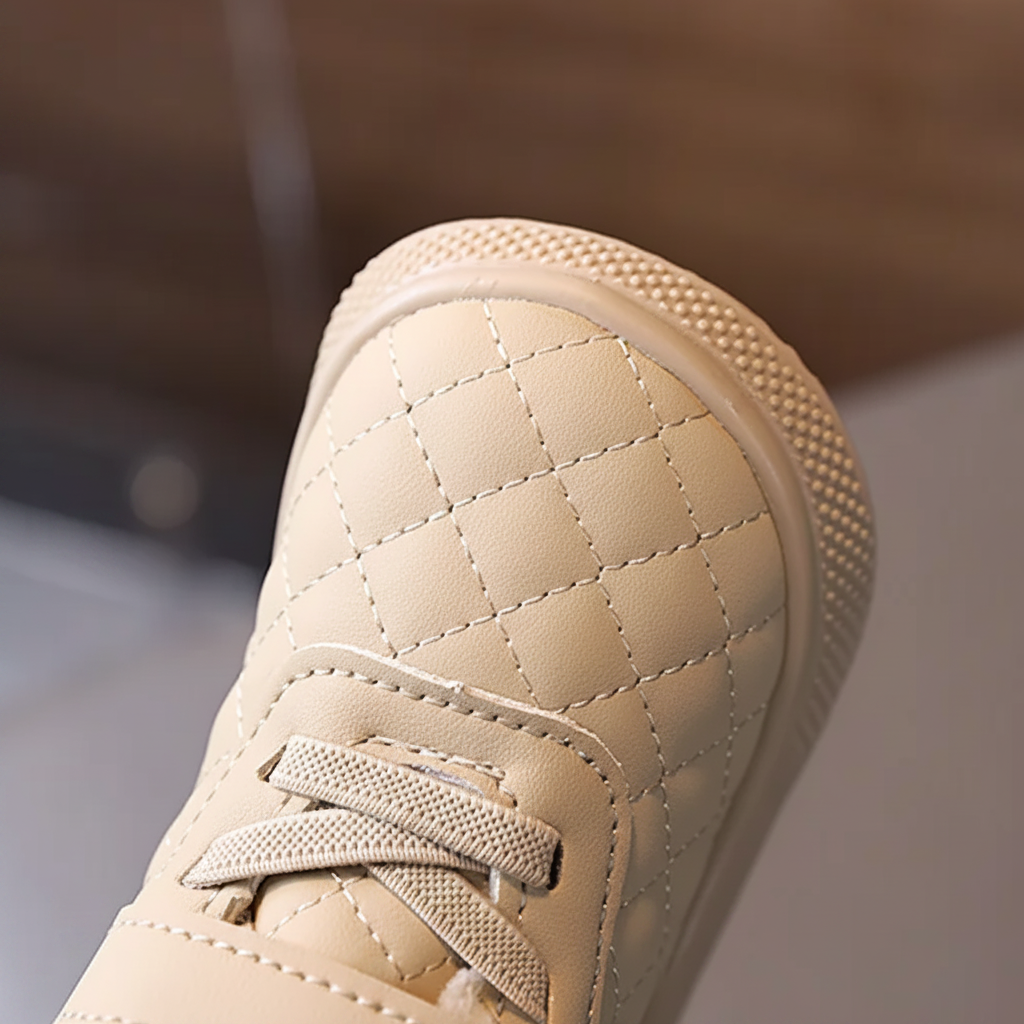 Close-up of the quilted toe and front laces on a beige winter boot