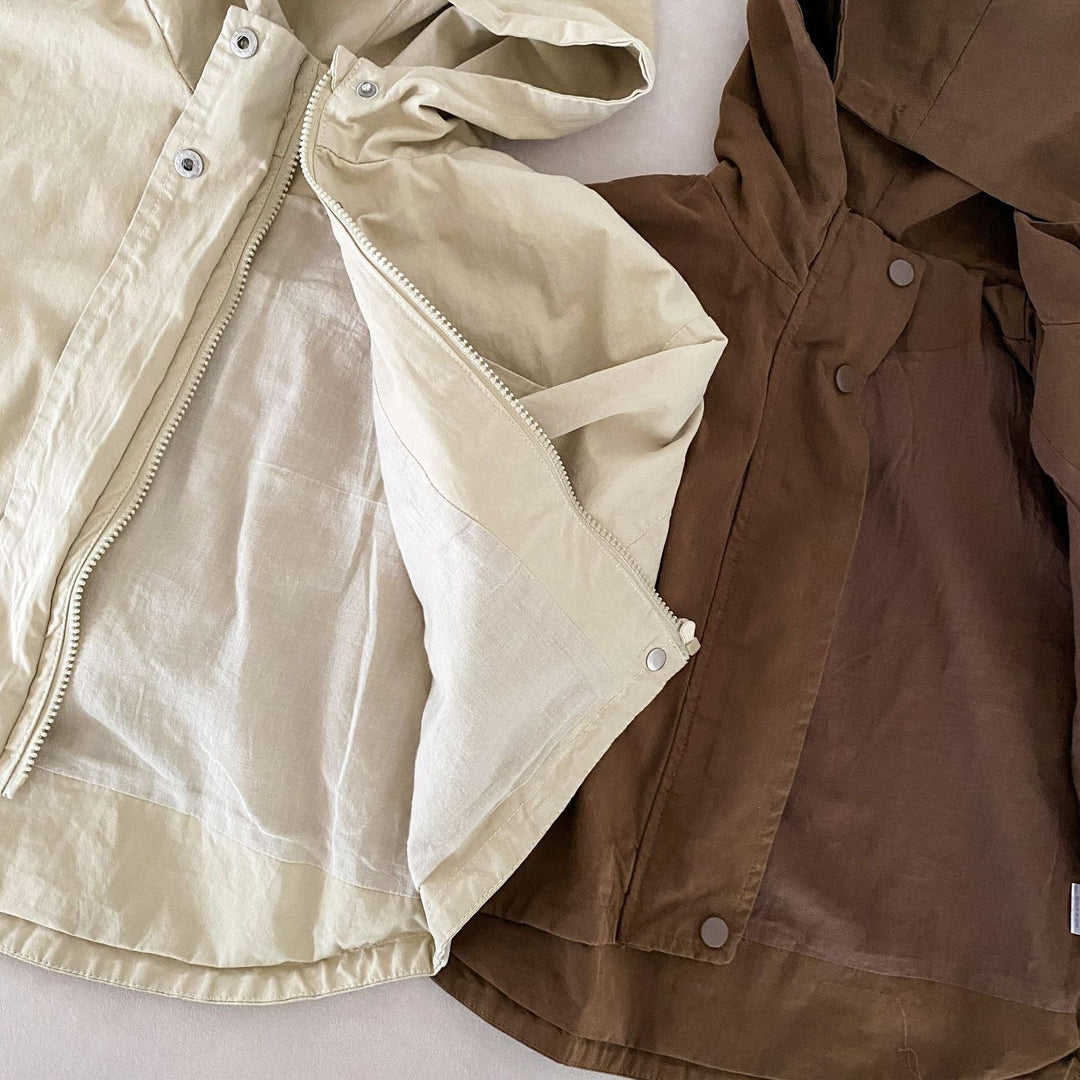 Close-up of beige and brown parkas with open fronts and visible interiors