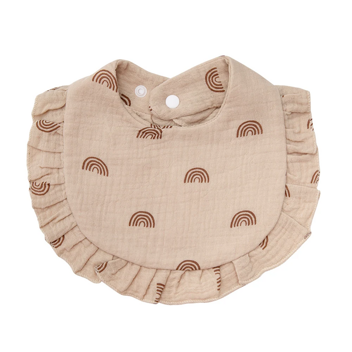 Beige cotton baby bib with brown rainbow motifs and a matching ruffled edge