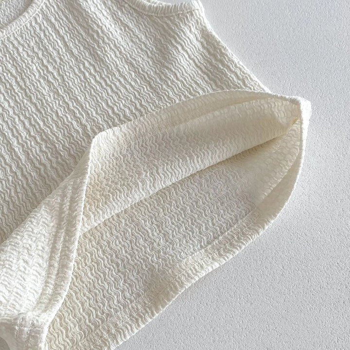 Close-up of the beige cotton fabric texture and stitched hem.