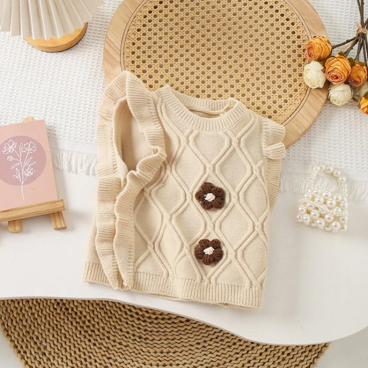 Beige floral knit vest with a textured diamond pattern and brown flower accents