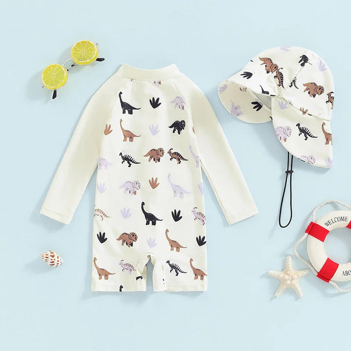 Beige dinosaur-print one-piece swimsuit with long sleeves, short legs, and a matching neck-flap hat.