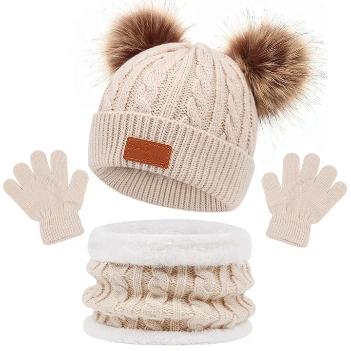 Beige cable-knit winter set with a double-pom-pom hat, loop scarf, and gloves