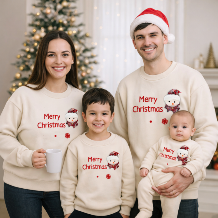 Family in matching beige Santa Christmas sweaters and a baby romper