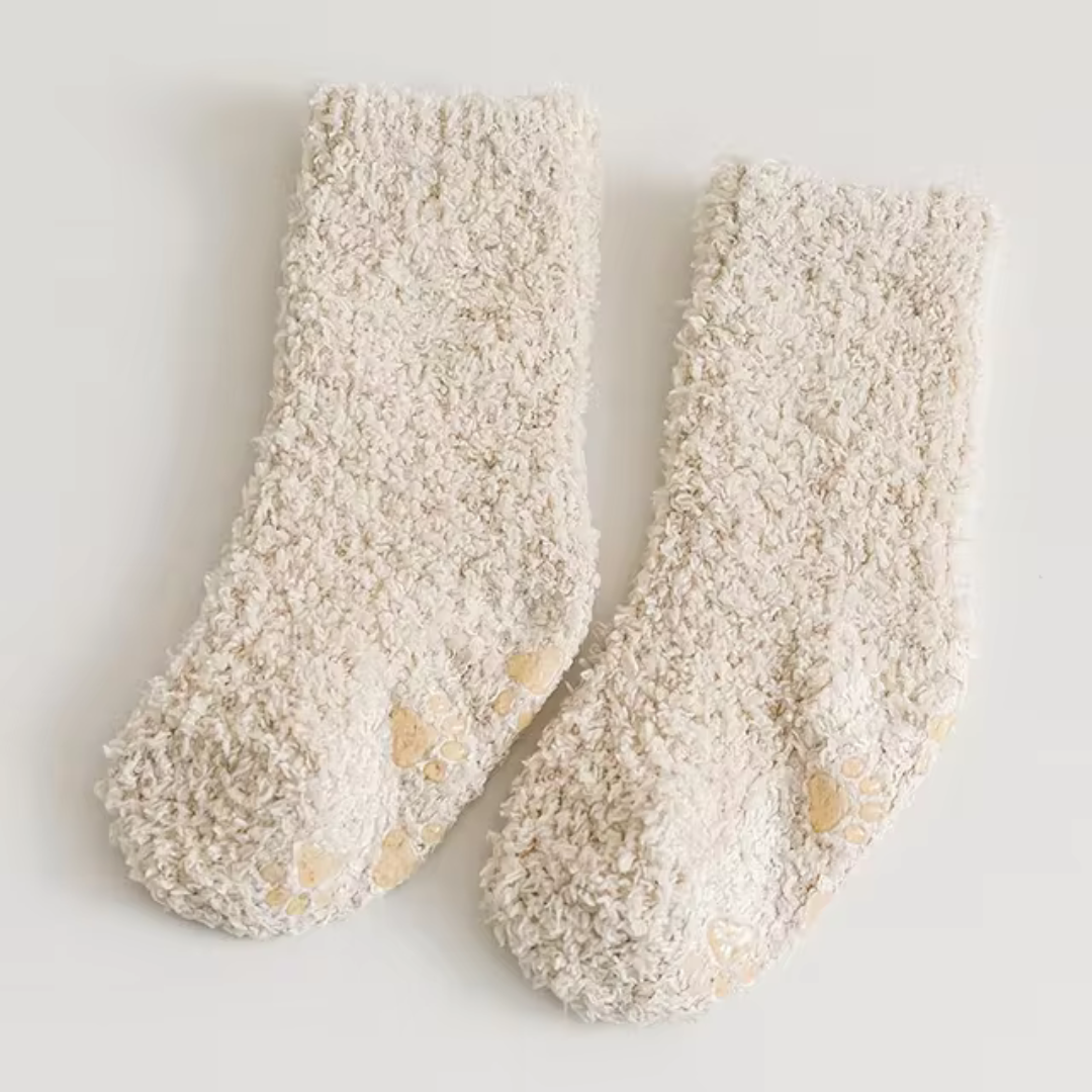 Beige fleece socks with subtle paw-print patterns on the soles.