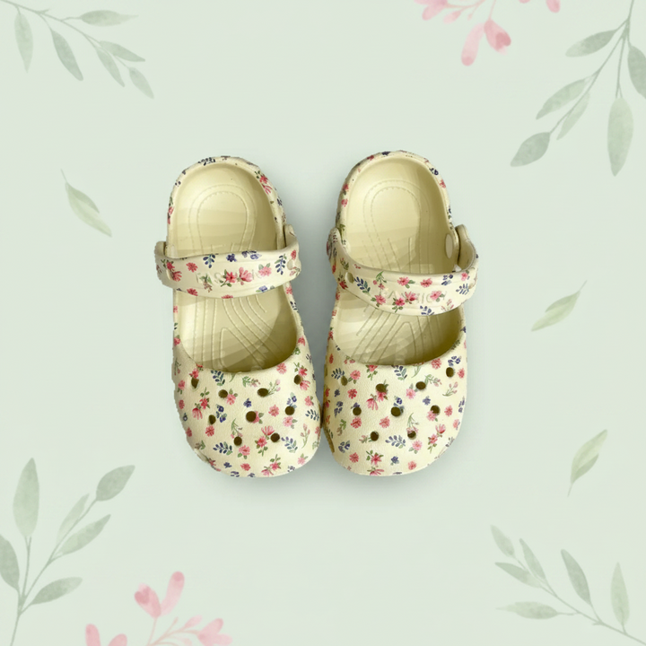 Beige floral sandals centered on a pale green background with a floral border