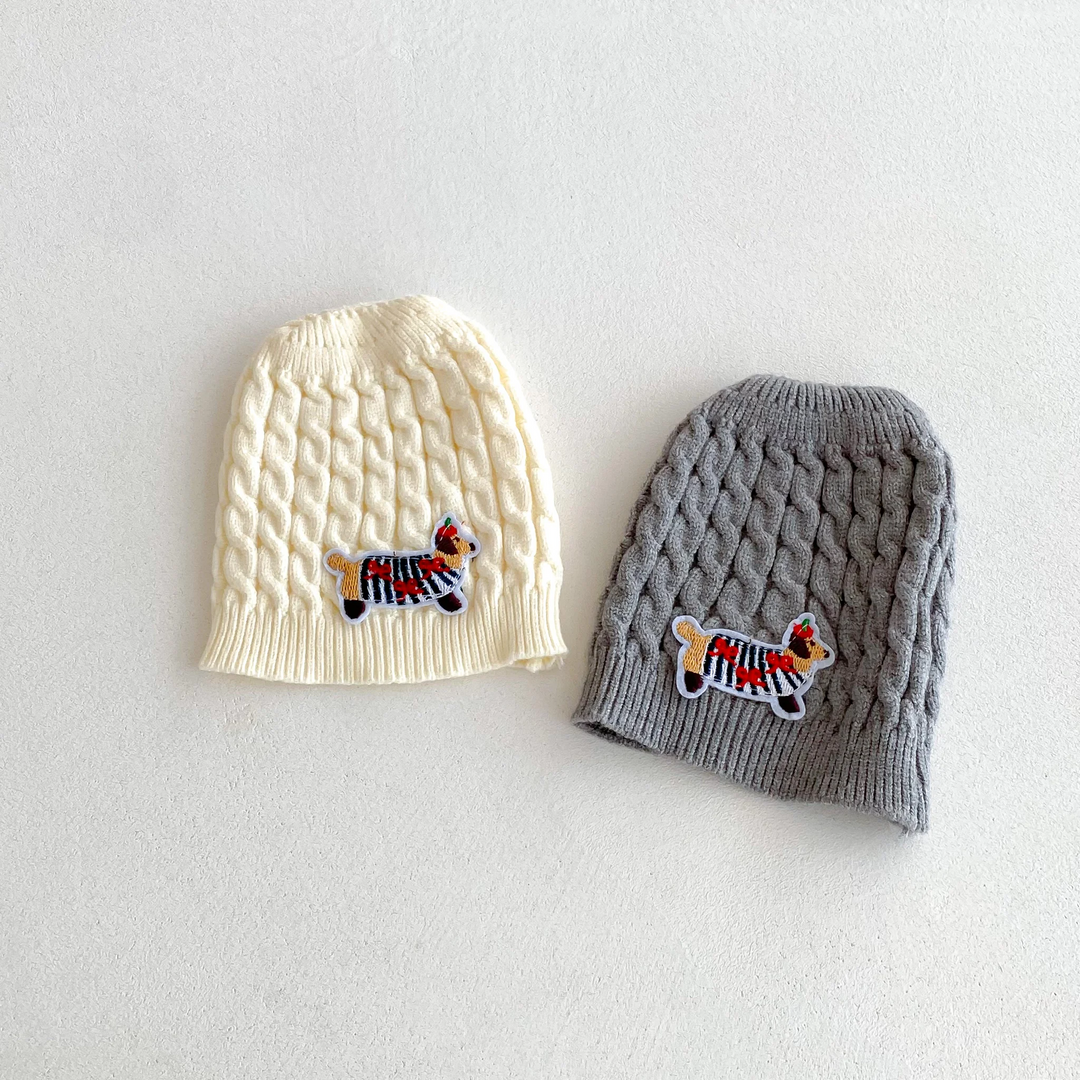 Beige and gray knitted baby hats with small colorful dog motifs