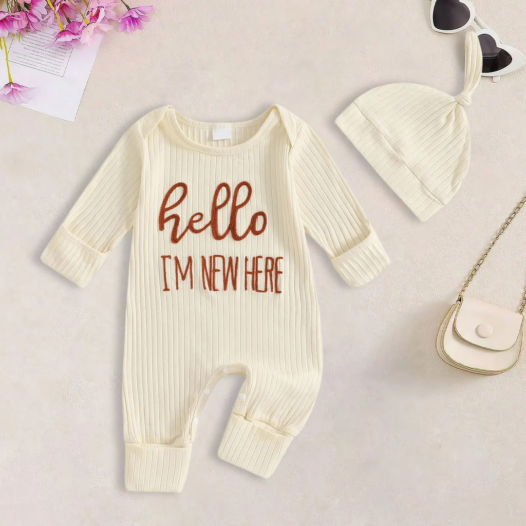 Beige ribbed baby jumpsuit with hello lettering and a matching knotted beanie