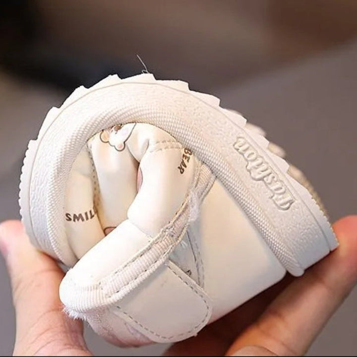 Beige animal-print boot bent by hand to show the upper and rubber outsole