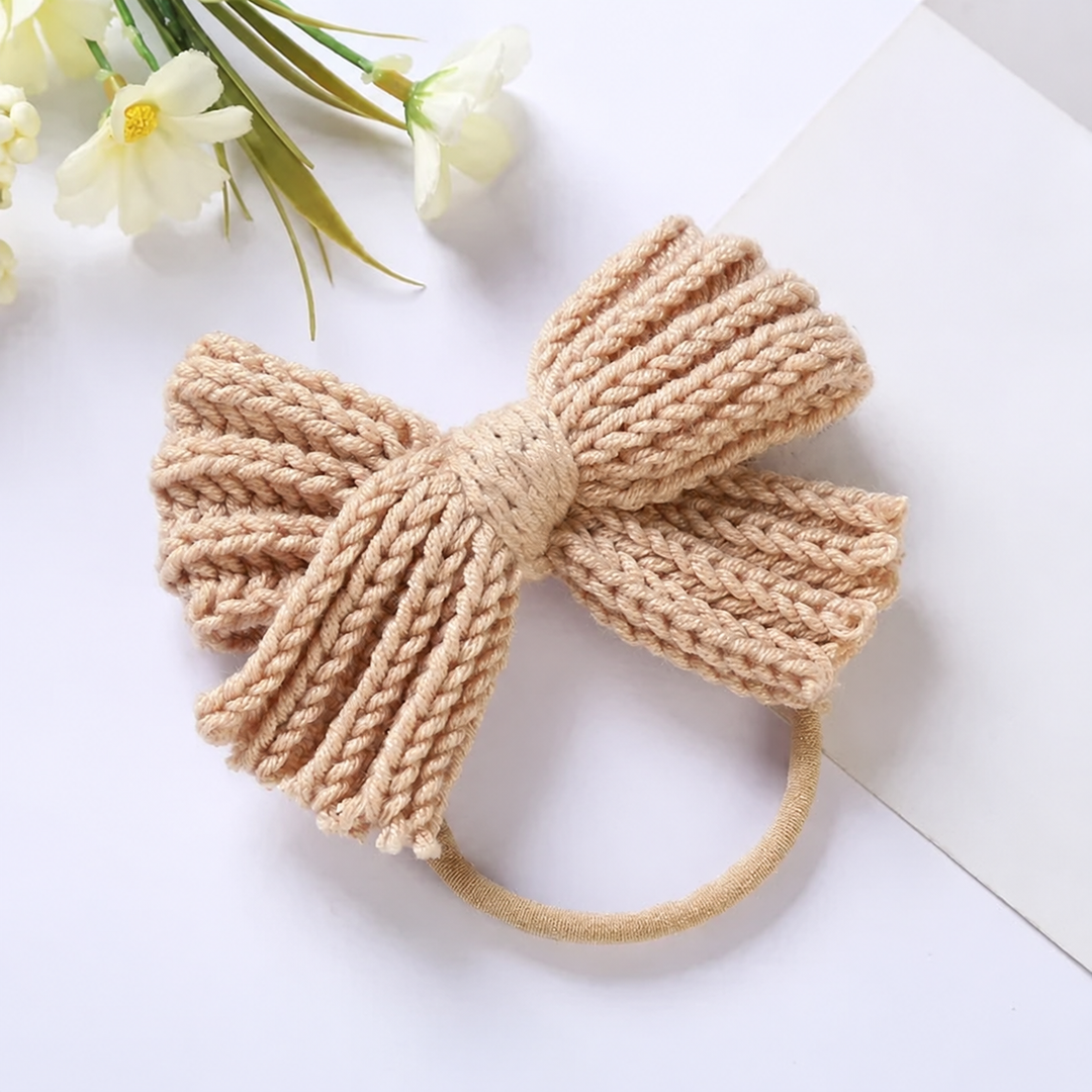 Beige knitted bow headband viewed from the front