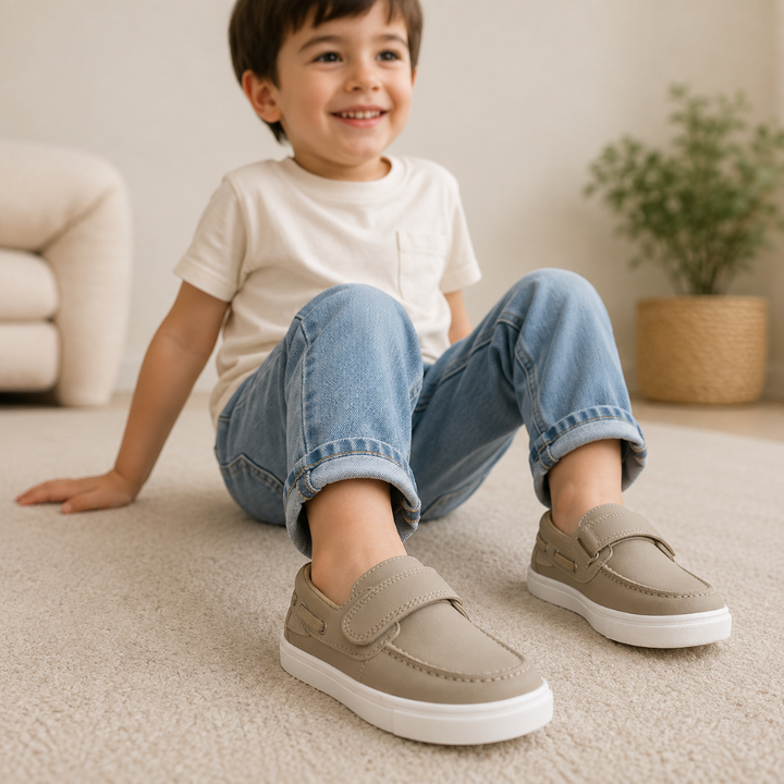 Child wearing beige loafer sneakers with jeans and a white T-shirt