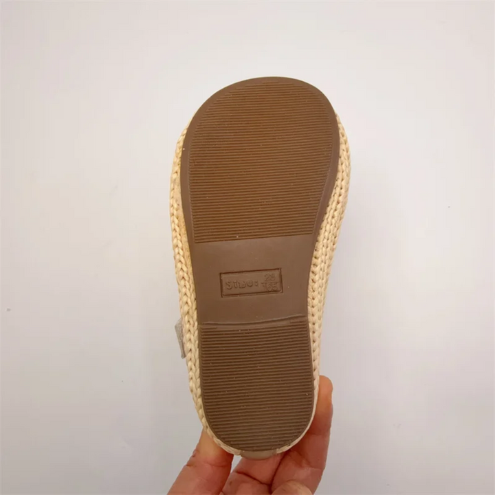Underside of a beige Mary Jane flat showing the ridged outsole
