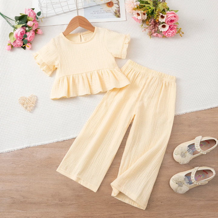 Front view of the beige ruffle top and matching wide-leg pants laid flat
