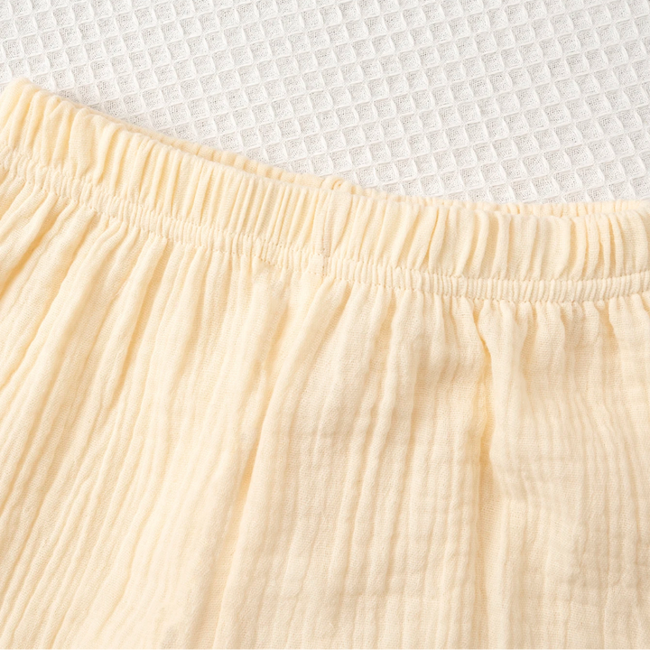Close-up of the gathered elastic waistband on the beige pants