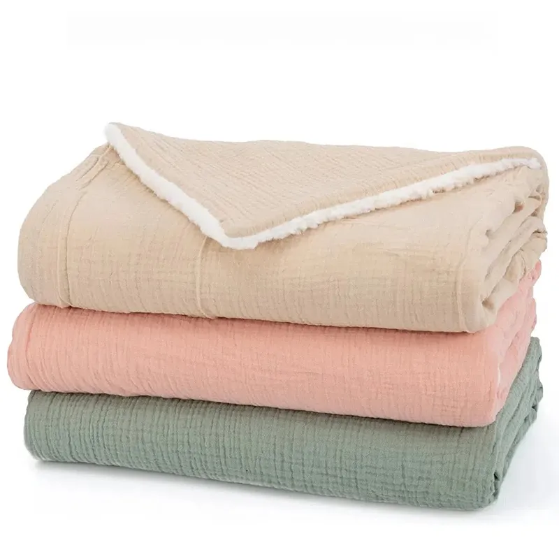 Folded beige, pink, and sage green baby blankets showing white sherpa backing