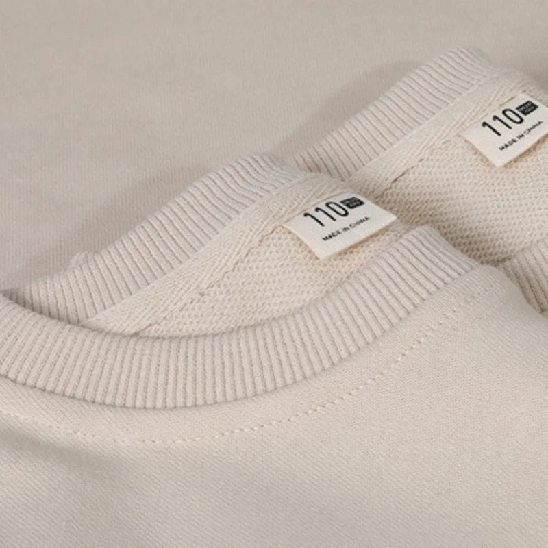 Close-up of ribbed crew necks on beige cotton Christmas sweaters