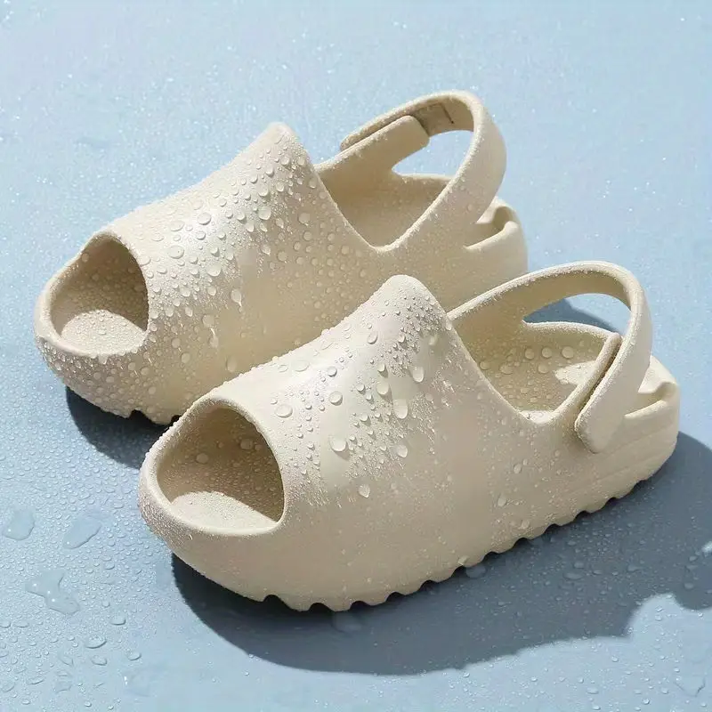 Beige open-toe sandals covered with water droplets on a blue surface.