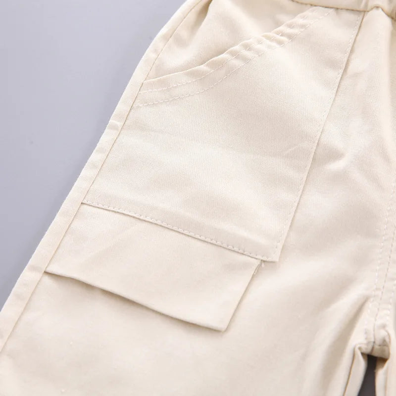 Close-up of the side pocket and flap detail on the beige shorts