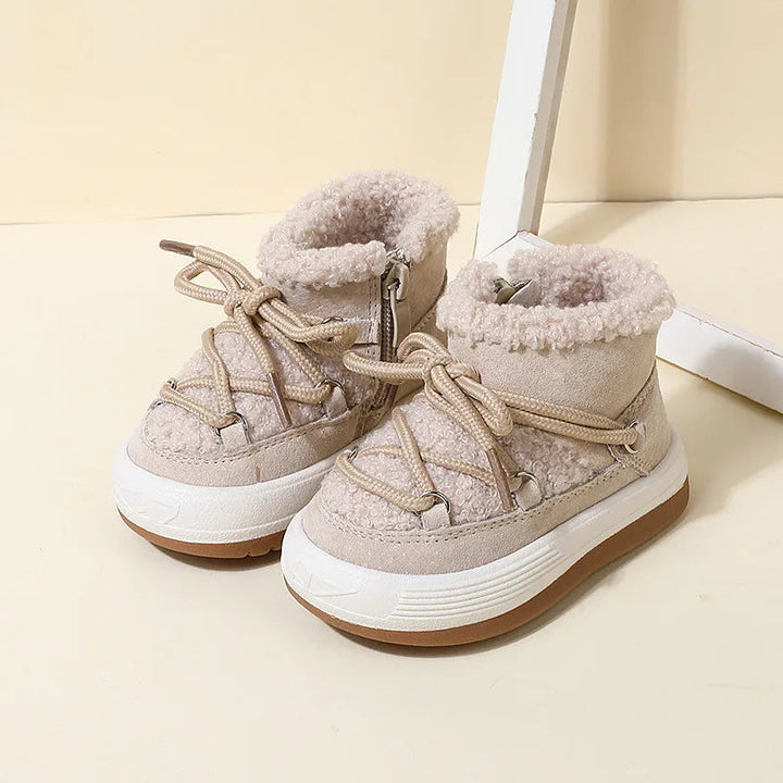 Pair of beige winter boots showing the side zipper and fluffy ankle collars
