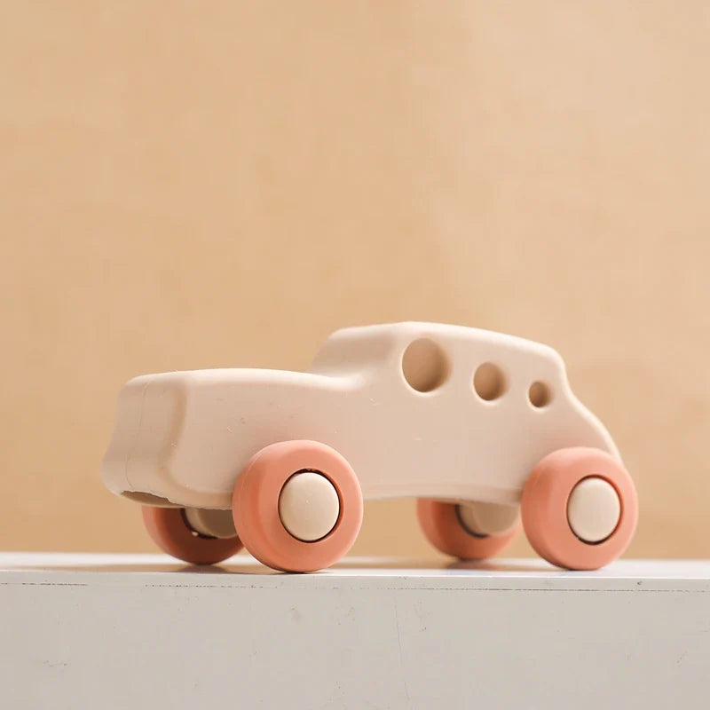 Beige silicone toy car with coral wheels and three round window openings