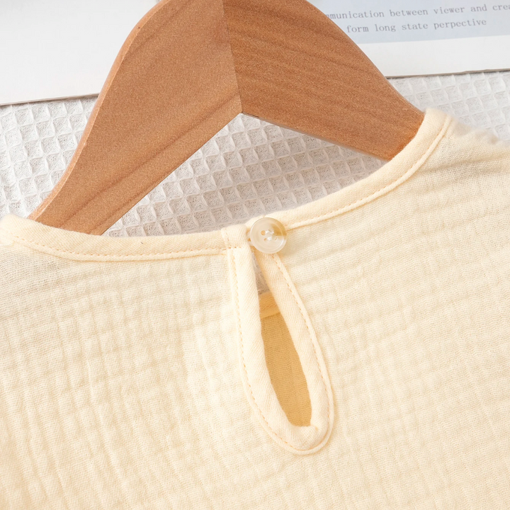 Back button and keyhole opening on the beige cotton top