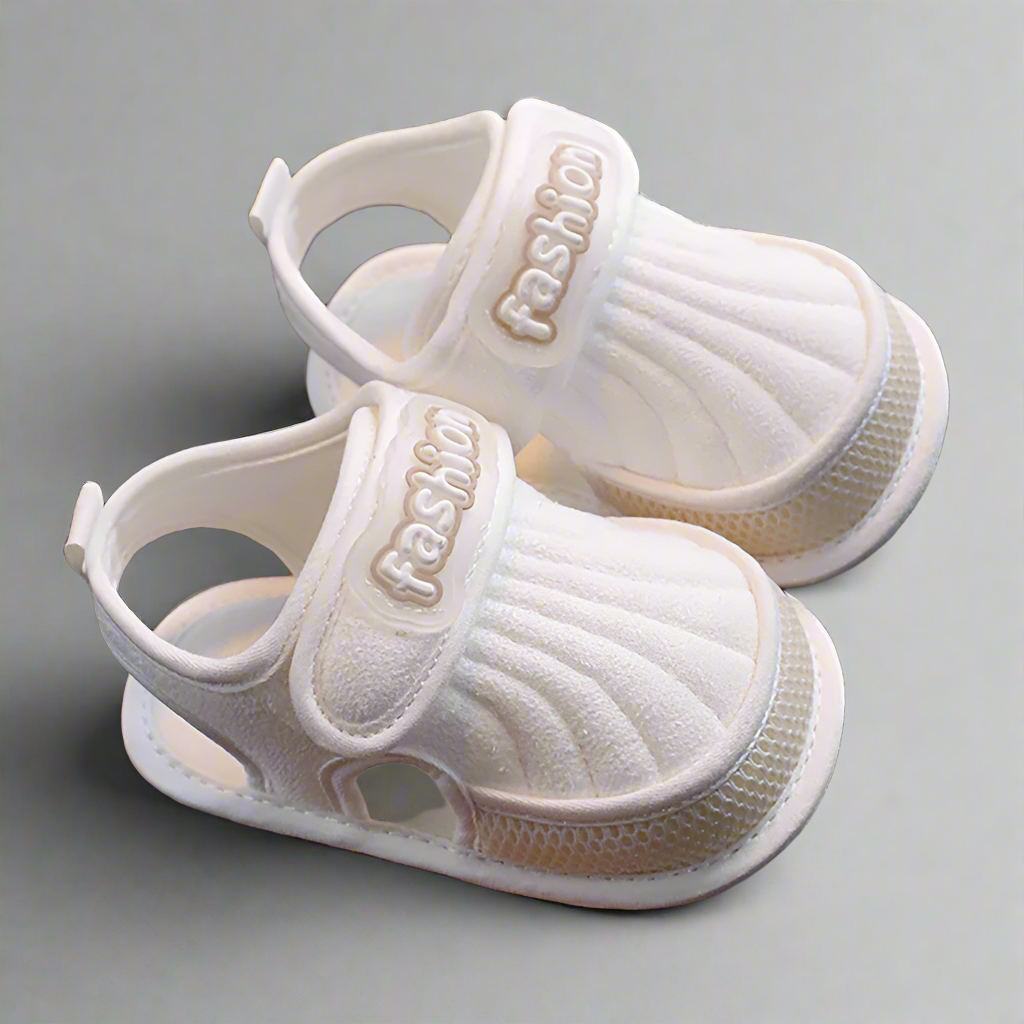 Pair of beige-trim baby sandals with closed toes and adjustable straps