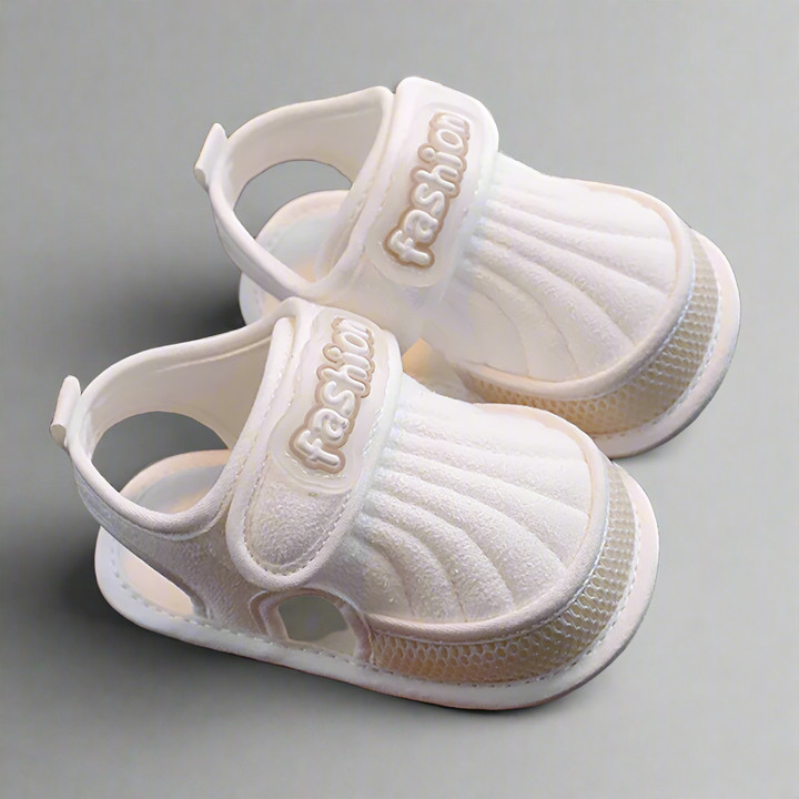 Pair of beige-trim baby sandals with closed toes and adjustable straps
