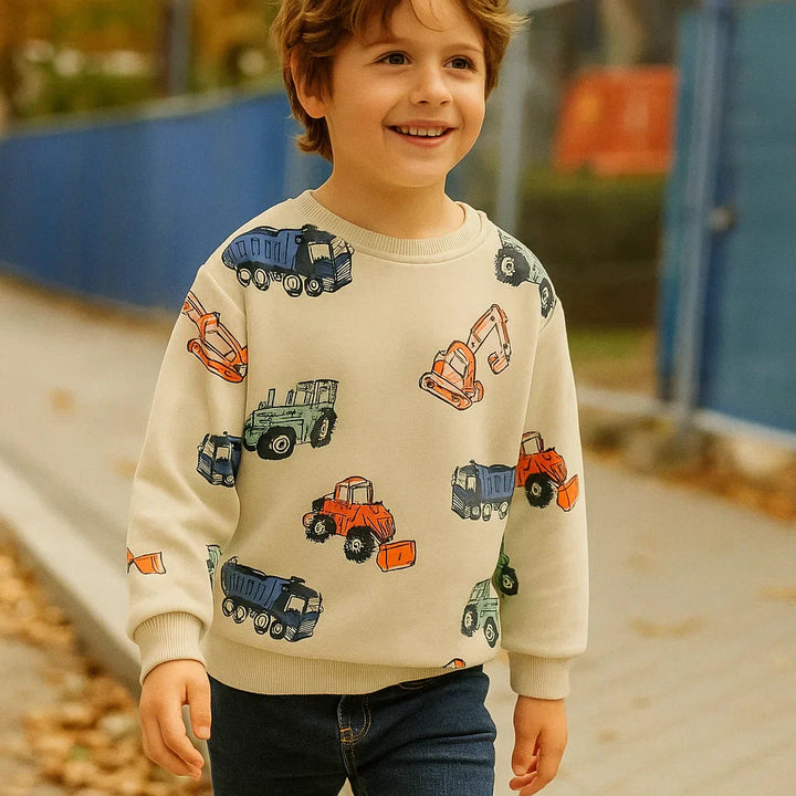Child wearing the beige construction print sweatshirt outdoors