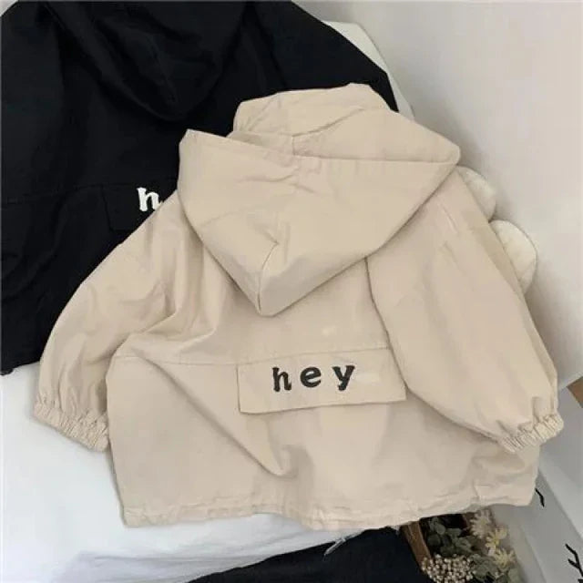 Back of the beige hooded jacket with gathered cuffs and a lettered panel