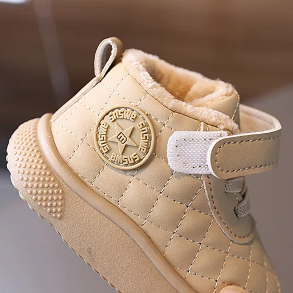 Open hook-and-loop ankle strap on a beige quilted winter boot