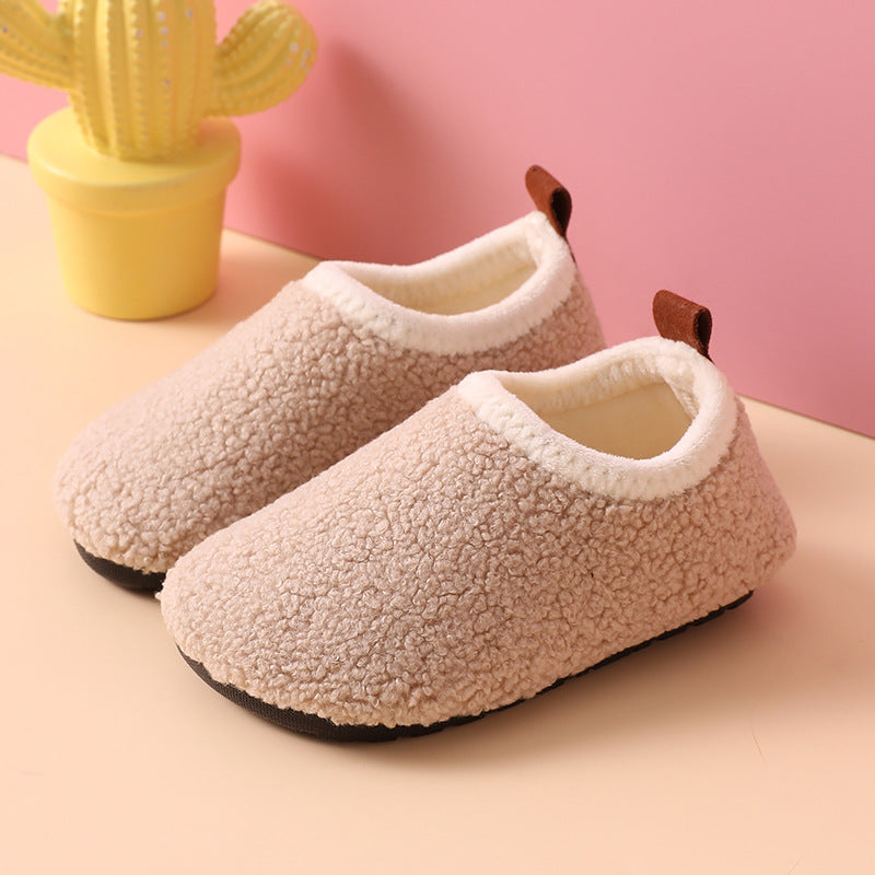 Beige wool slippers with cream-colored openings, brown heel pull tabs, and black soles