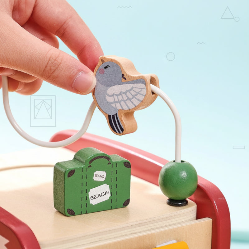 Hand moving a bird-shaped bead along the wooden bus&
