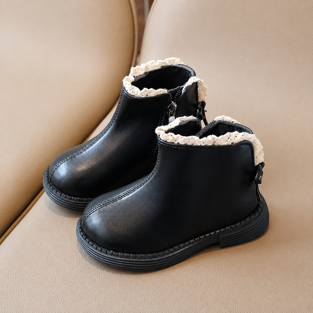 Pair of black ankle boots with rounded toes, black soles, and cream trim