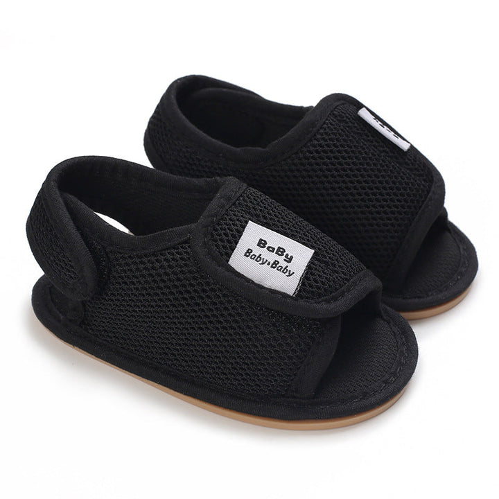 Black mesh baby sandals with adjustable straps and tan sole edges