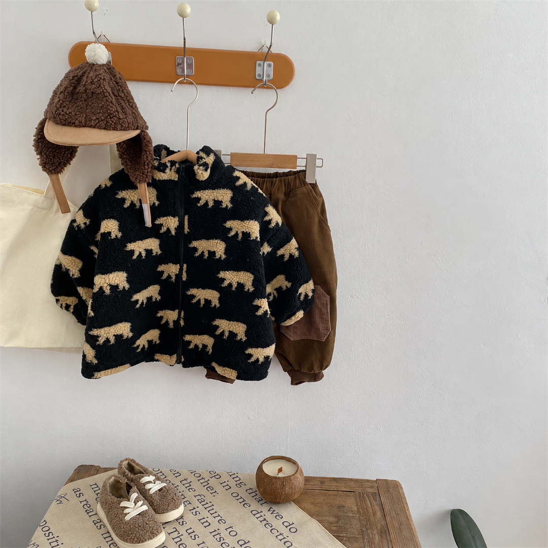 Black bear-print fleece jacket displayed on a wall rack above a wooden table