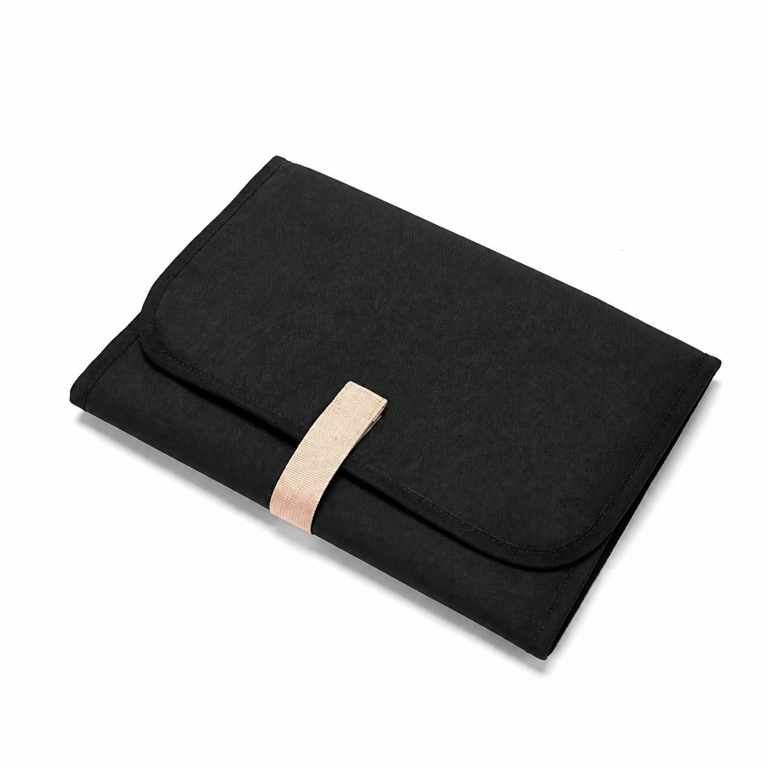 Black baby changing mat folded with a beige front strap