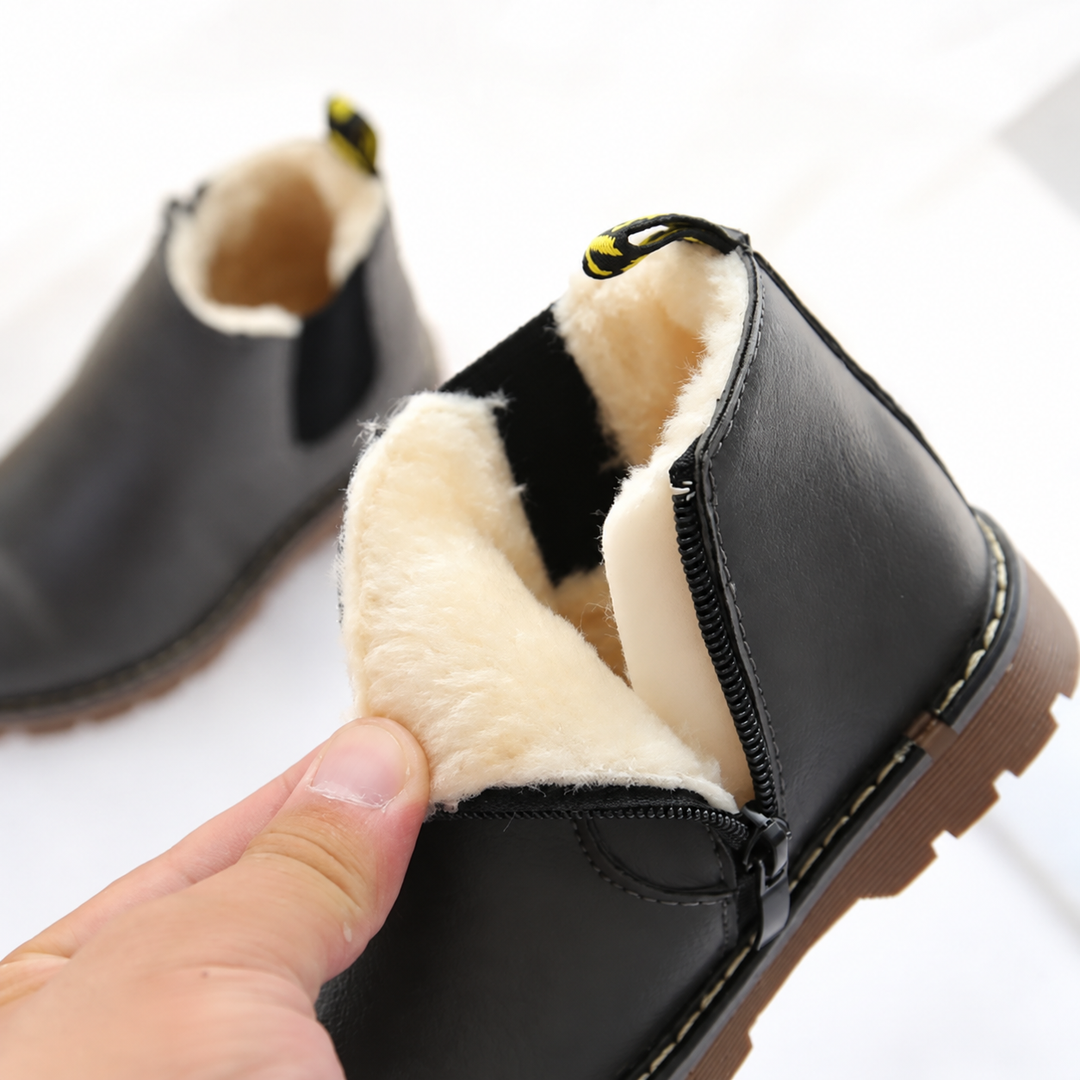 Black Chelsea boot opened to show the cream-colored lining and side zipper
