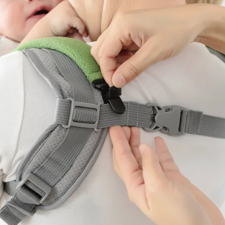 Close-up of a black cover clip fastening to a gray baby carrier strap