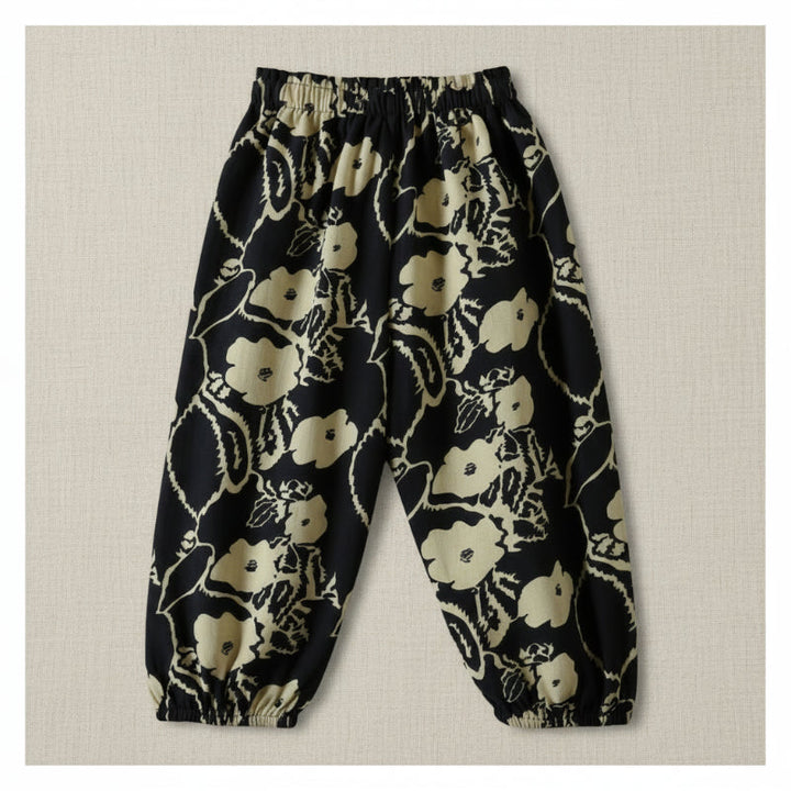 Black harem pants with a cream floral and vine print and elastic ankle cuffs.