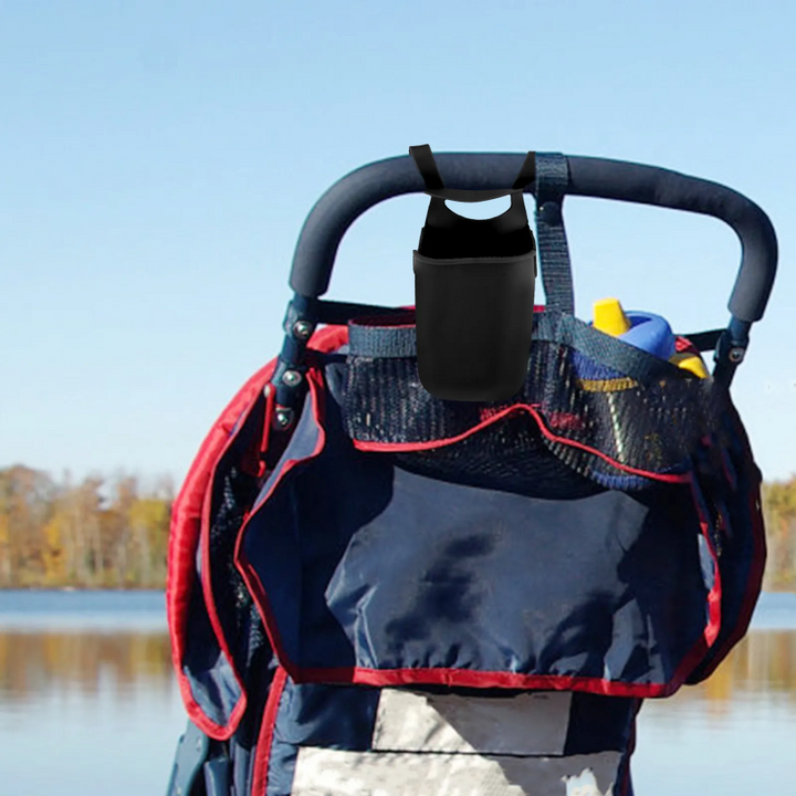 Black silicone cup holder attached to a stroller handle above an organizer bag.