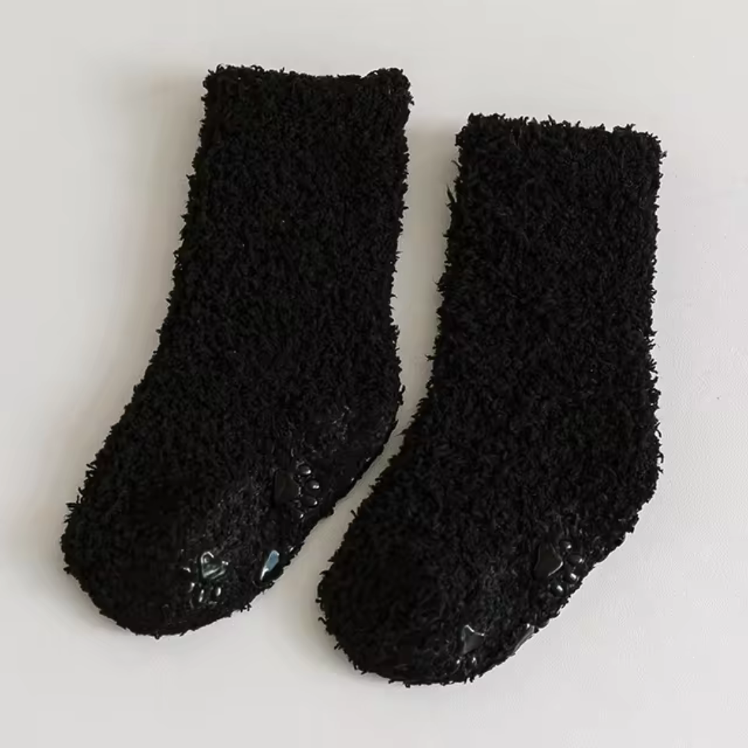 Black fleece socks with paw-print patterns visible along the soles.